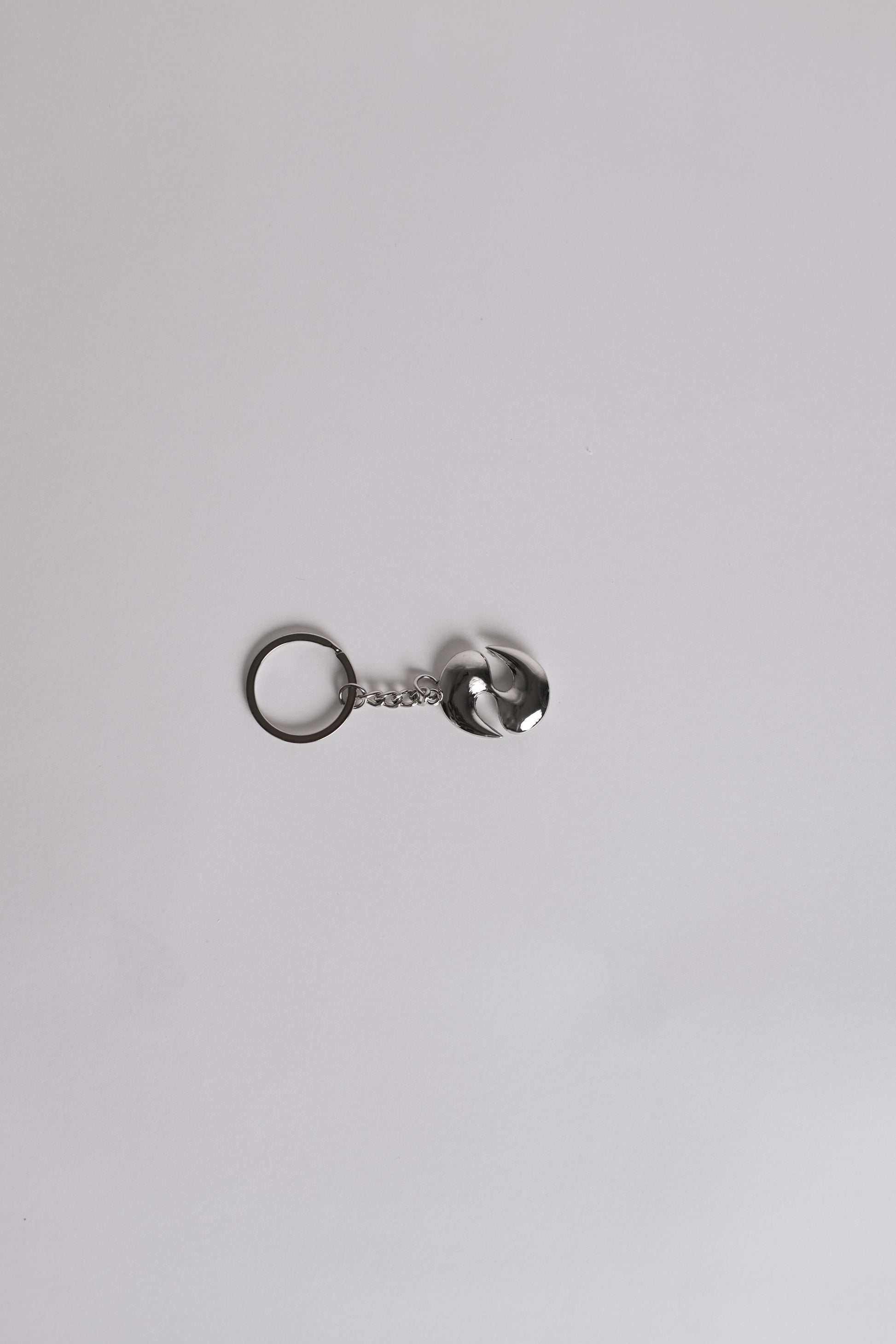 Silver keychain with a small round tag on a light gray background