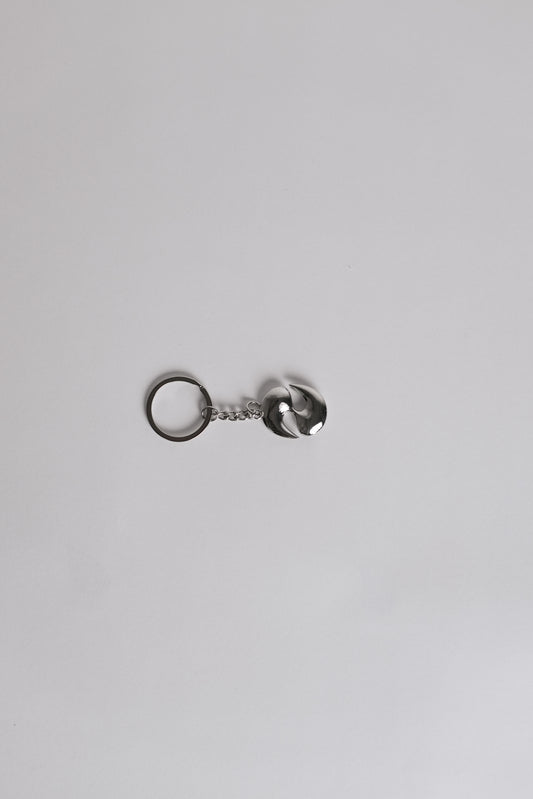 Silver keychain with a small round tag on a light gray background